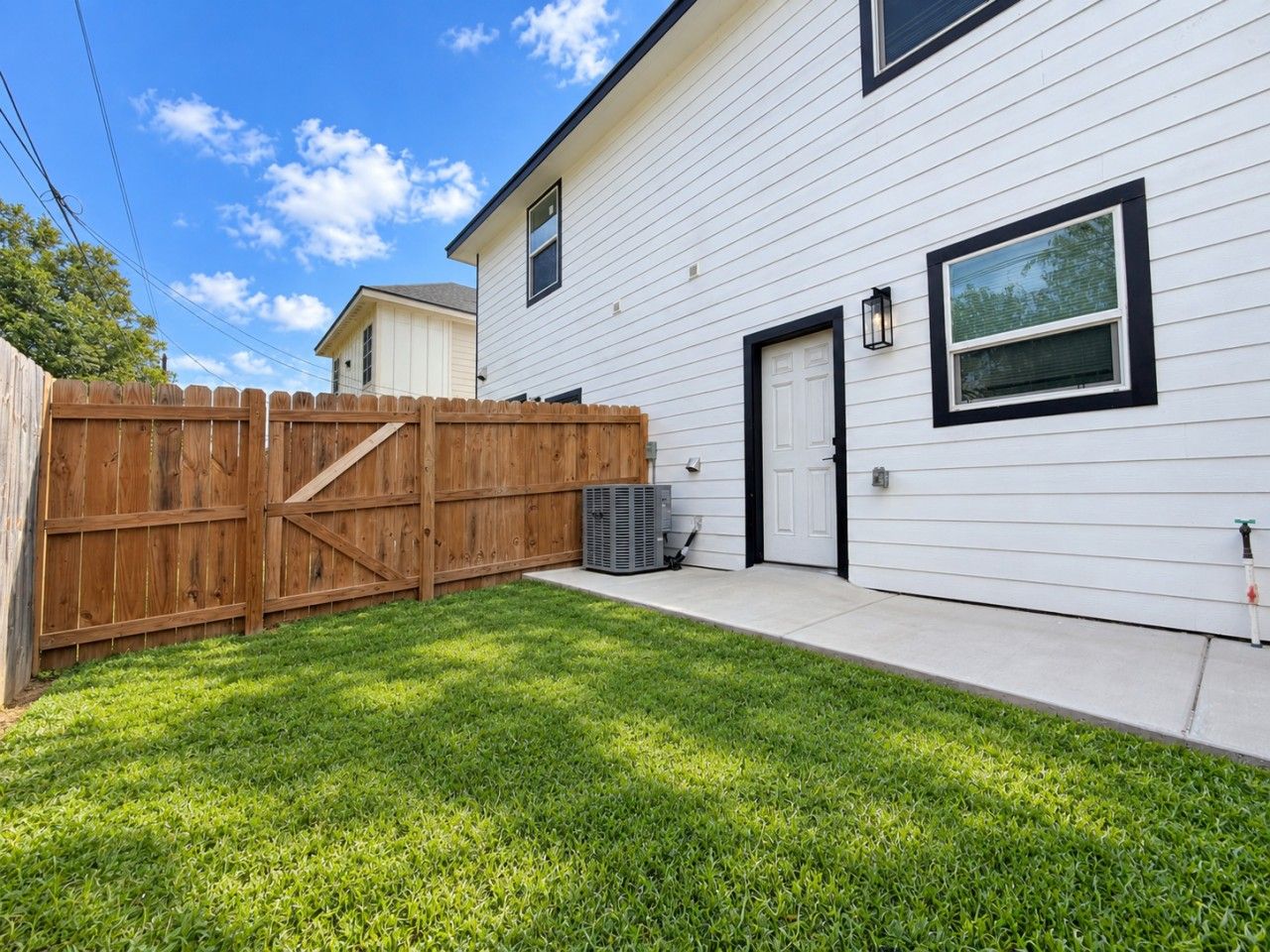 A residential house with a fenced yard and a side door.