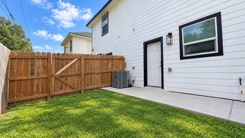 A residential house with a fenced yard and a side door.