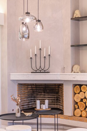A modern interior with a fireplace, a candelabra, and a table with a vase. - Mimosa Urban Granden - 200 m² - 2 Lounges - 3 Bedrooms/3 Baths - Private Parking (Chania)
