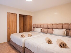 A double bed with a headboard, a wooden wardrobe, and a door. - Polanco 1BR on Newton with 2 Queen Beds and Elevator (Ciudad de México)