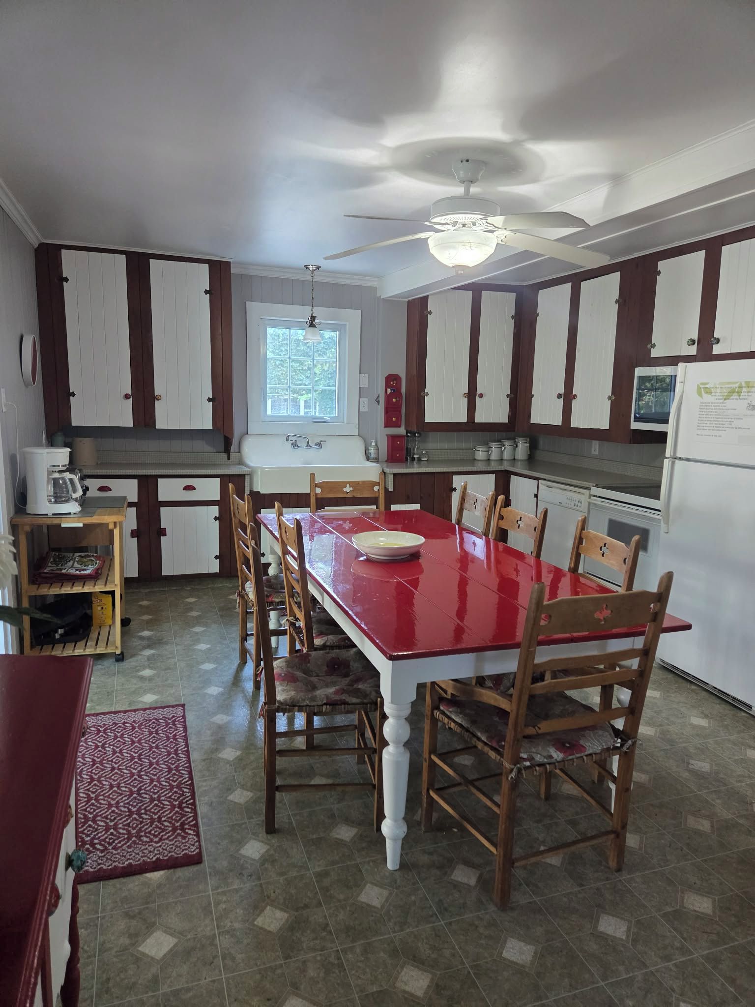 A kitchen with a central island, wooden cabinets, a built-in oven, and a ceiling fan.