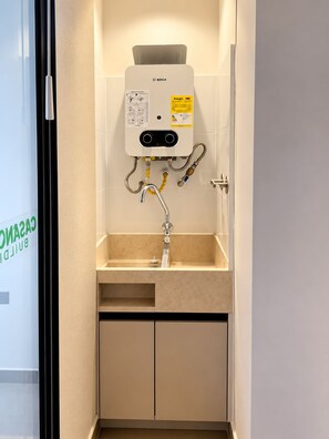 Un baño con calentador Bosch, un lavabo y un espejo.