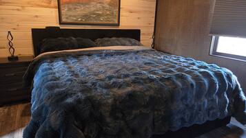 Une chambre à coucher avec un lit, une table de chevet, un tableau accroché au mur et une fenêtre.