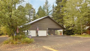 A single-story building with a garage, surrounded by trees.