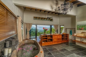 A spacious bathroom with a large bathtub, wooden vanity, and a view of the outdoors. - Beauty of Costa Rica by Pura Villas (Bahía Ballena)