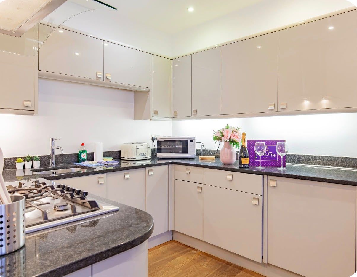 A modern kitchen with a gas stove, microwave, and cabinets.
