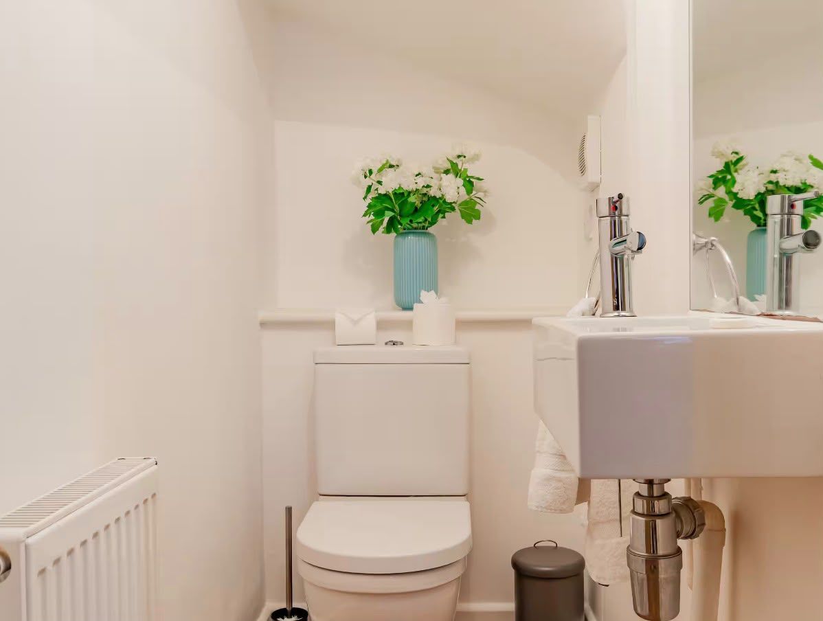 A small bathroom with a toilet, a sink, and a radiator.