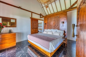 A bedroom with a bed, wooden headboard, marble flooring, and a dresser. - Bali Villa Jungle Paradise by Pura Villas (Bahía Ballena)