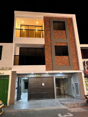 A multi-story building with a ground-level garage and a sign indicating 'APARTAMENTOS 5-72 La Riviera'. - New 2BR Apt with A/C & Pool Access, Downtown Cartago (Cartago)