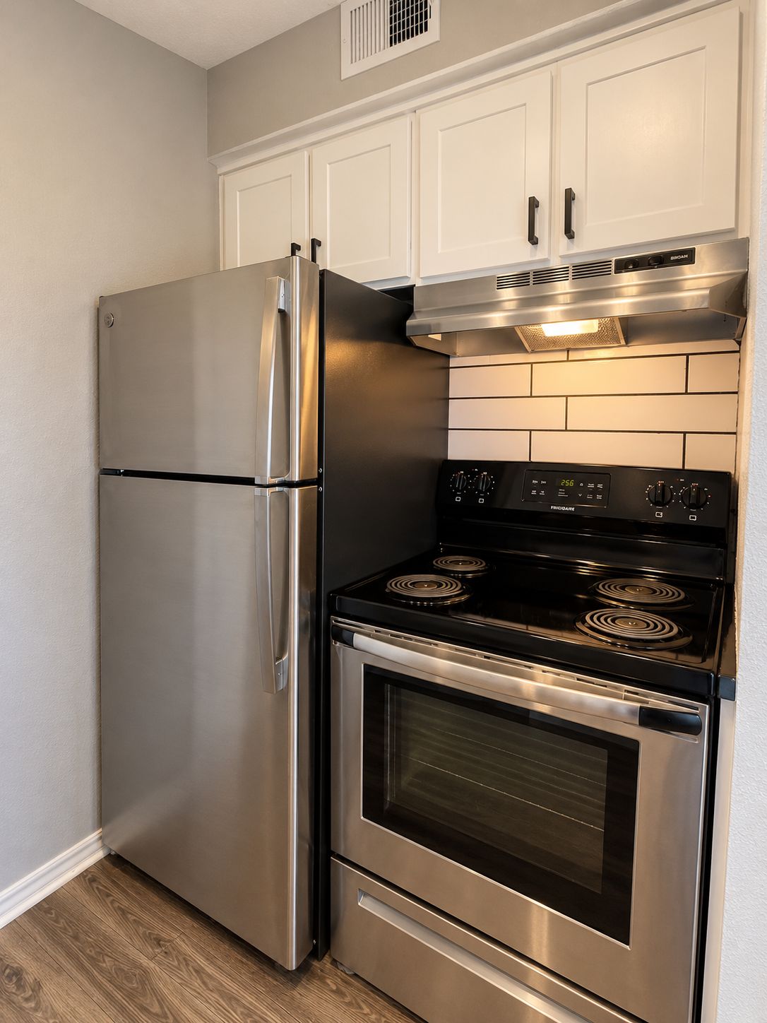 A kitchen with stainless steel appliances, including a refrigerator and an oven.