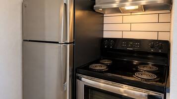 A kitchen with stainless steel appliances, including a refrigerator and an oven.