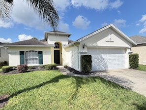 A single-story house with a garage, a front door, and a small porch. - The Sunset Retreat - Close to Disney World (Davenport)