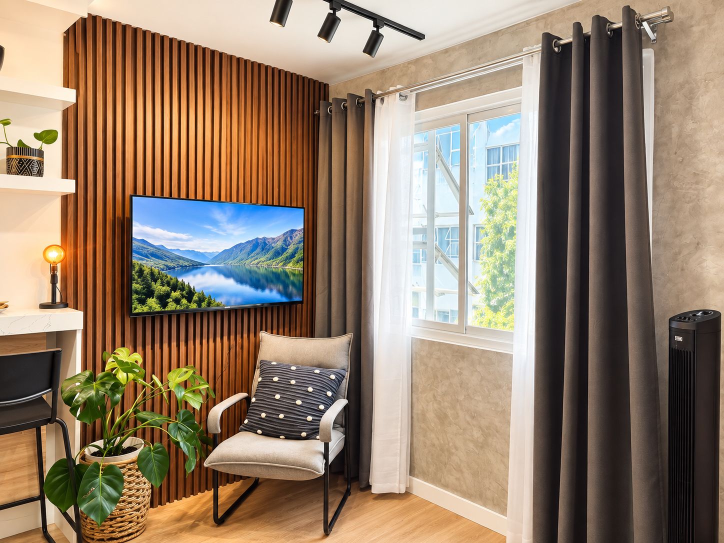 Een moderne woonkamer met een flatscreen televisie bevestigd aan een houten paneelwand, een comfortabele fauteuil met een kussen, een potplant en een raam met gordijnen.