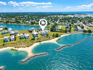Un quartier résidentiel situé sur la côte, avec des maisons à proximité d’un lac et d’une plage.