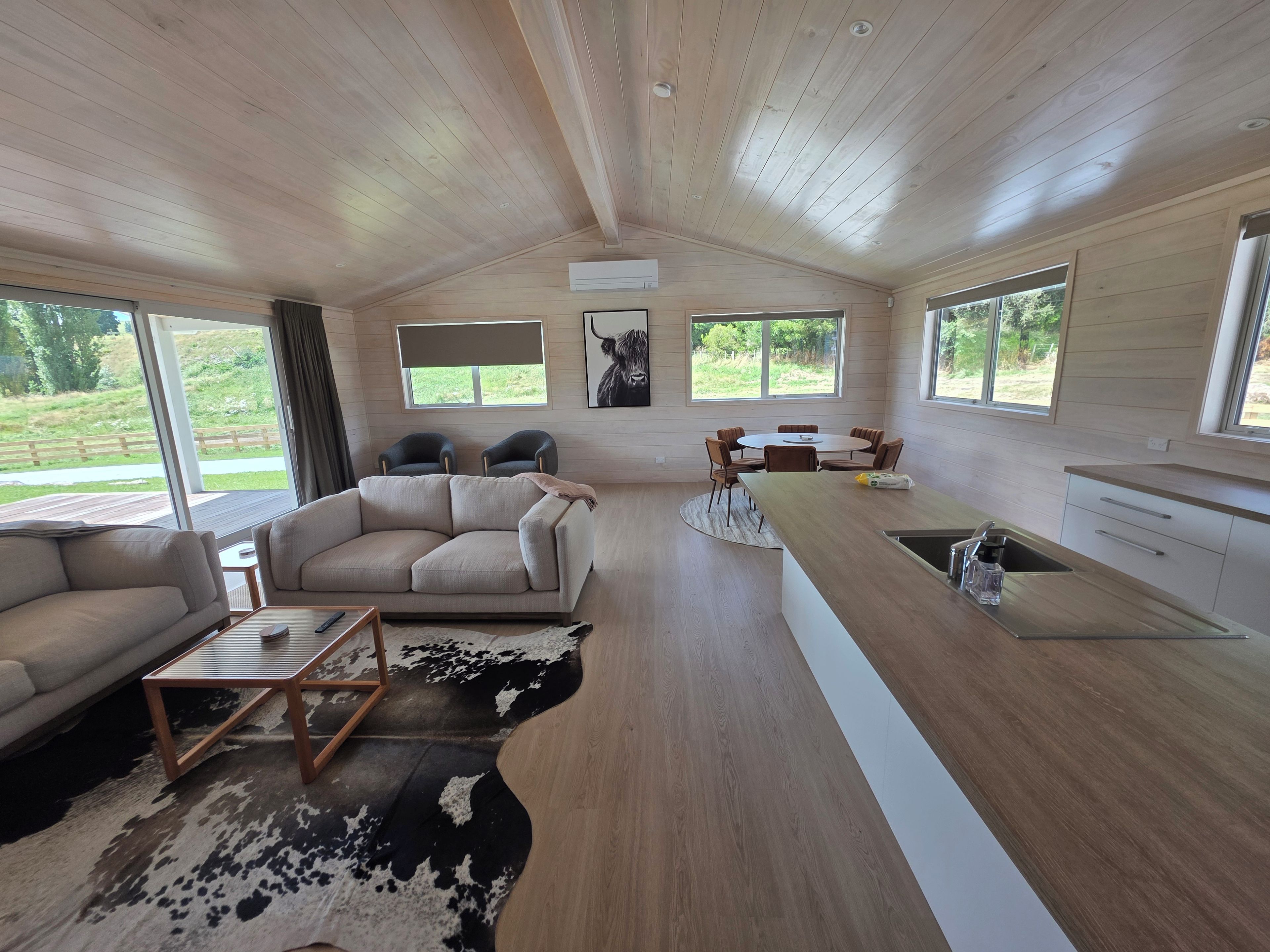 A modern interior with a sofa, dining table, and kitchen area.