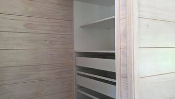 A corner of a room with wooden paneling and a white built-in shelving unit.