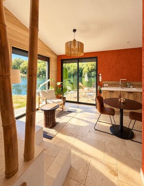 A modern interior with a dining area, a kitchen, and a view of a pool. - New Listing (Sainte-Livrade-sur-Lot)