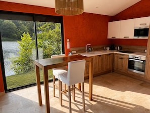 A modern kitchen with a large window, wooden cabinets, and a dining area. - New Listing (Sainte-Livrade-sur-Lot)