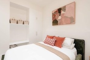 Ein Schlafzimmer mit einem Bett, einem Kleiderschrank und einem Bild an der Wand.