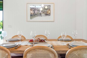 A dining table set for six with a framed picture above it. - The Breezy Abode - Dog-Friendly, Views & Deck (Caloundra Region)