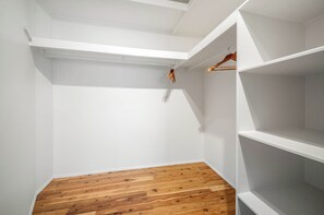 A closet with white shelving and wooden flooring. - The Breezy Abode - Dog-Friendly, Views & Deck (Caloundra Region)