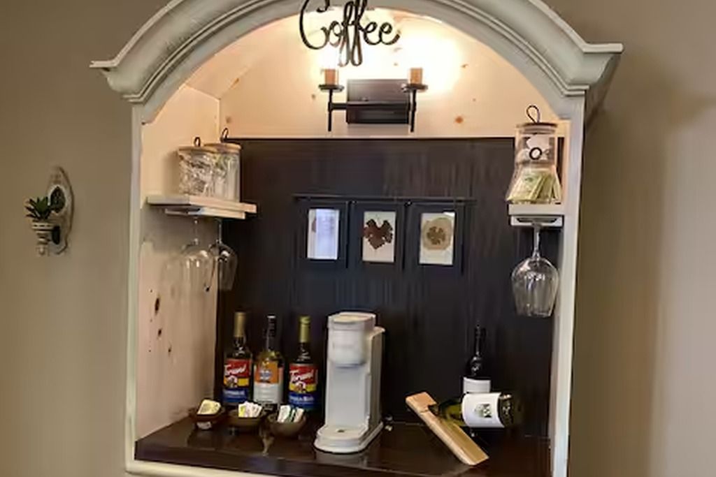 En kaffestation med en kaffemaskin, socker, grädde och en kaffekvarn.