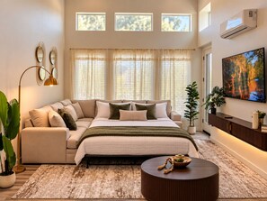 A bedroom with a bed, a sofa, a coffee table, and a TV. - The Napa Luxe Brand-New 2BR/2BA Sleeps 6. (Napa)