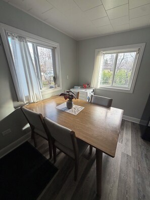 A dining area with a wooden table, chairs, and a potted plant.