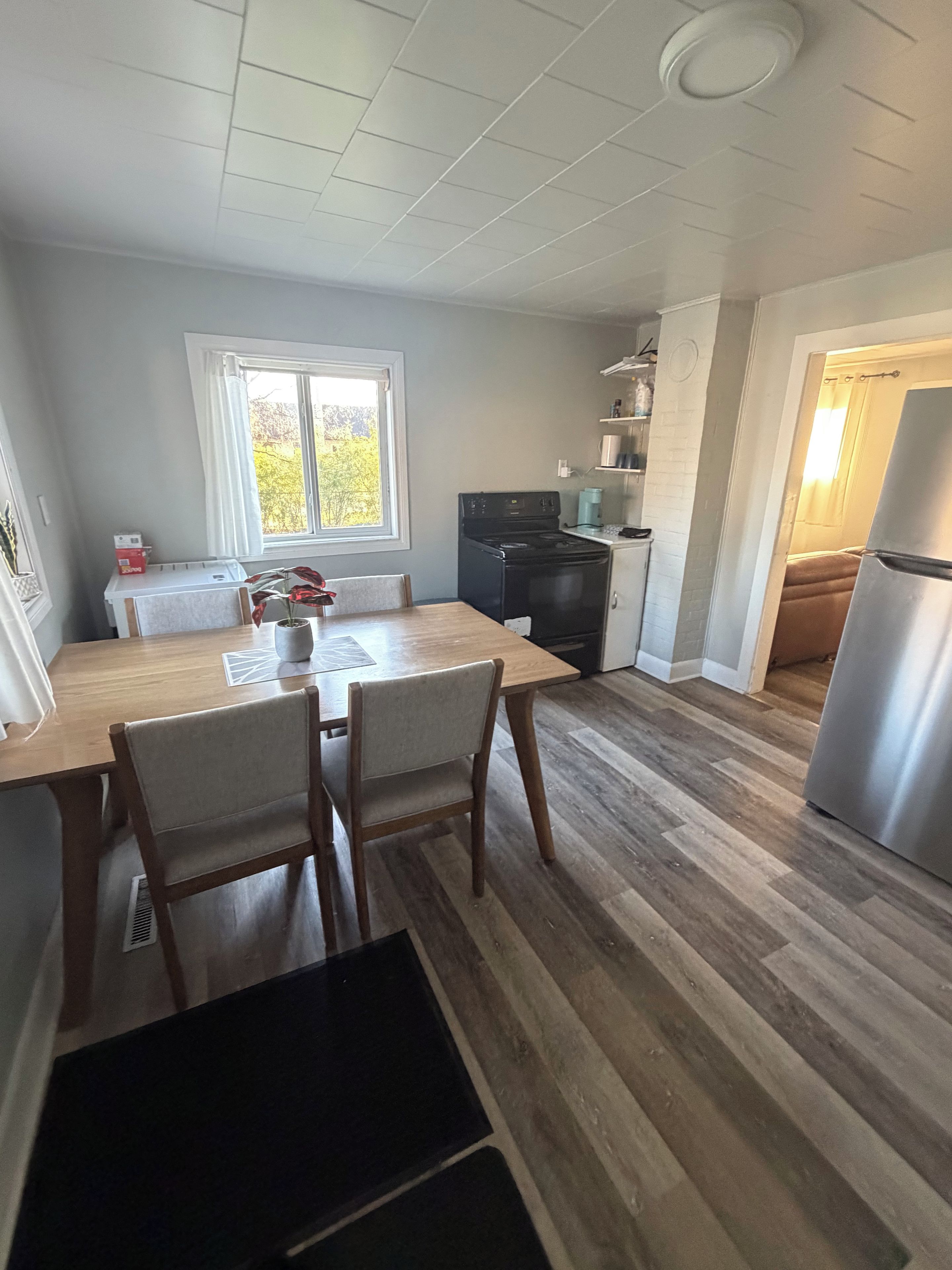 Une cuisine équipée d’une table à manger, de chaises, d’une cuisinière et d’un réfrigérateur.