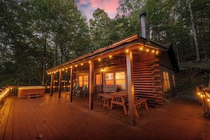 A wooden cabin with a porch, outdoor seating, and a hot tub. - Disconnect at Bearly Connected (Ellijay)