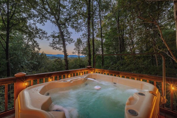 A hot tub on a wooden deck with a view of a forest and mountains in the background. - Disconnect at Bearly Connected (Ellijay)