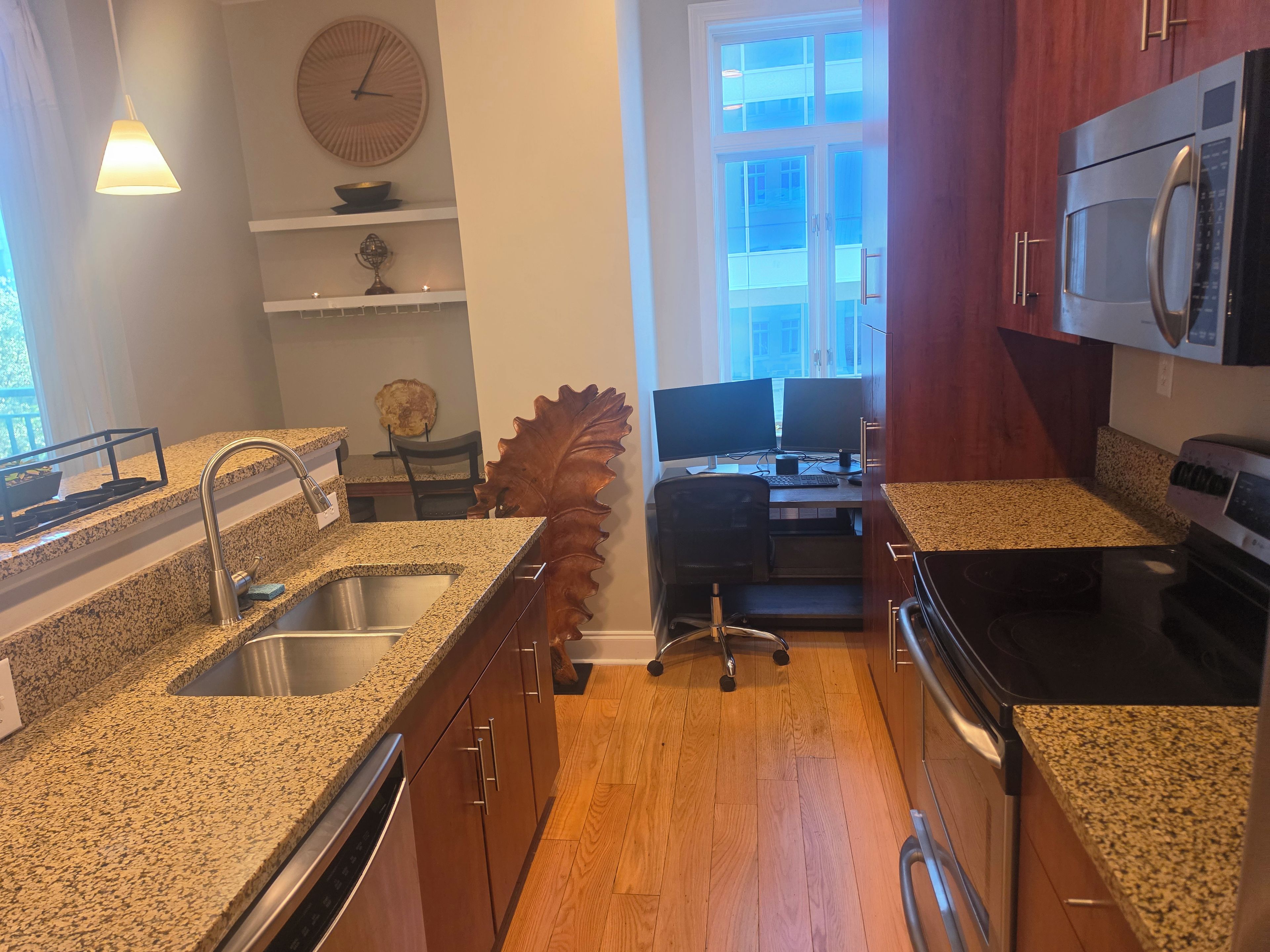 A kitchen with granite countertops, stainless steel appliances, and wooden cabinets.