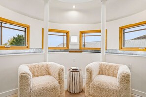 A room with two plush armchairs, a small wooden table, and a view of the outside through large windows. - Empire House 2BR | Sleeps 6 | Walk to Park City Mountain | Free Bus (Park City)