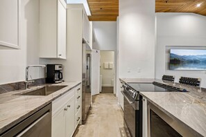A modern kitchen with a built-in oven, a coffee maker, and a large window overlooking a scenic landscape. - Empire House 2BR | Sleeps 6 | Walk to Park City Mountain | Free Bus (Park City)