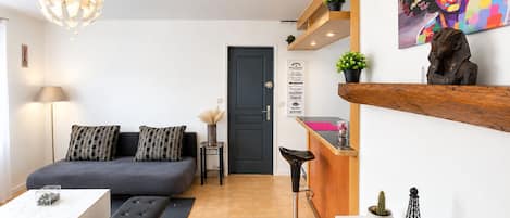 Un salon moderne avec un canapé, une table basse et un luminaire sphérique original.