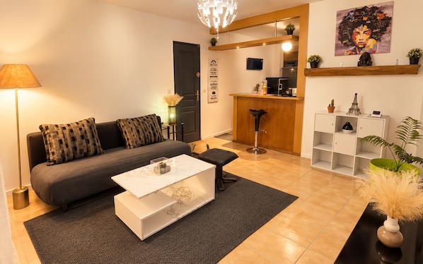 Ein modernes Wohnzimmer mit einer Couch, einem Couchtisch und einer kleinen Bar mit Hockern.