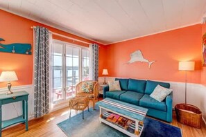 Un salon avec un canapé, un fauteuil, une table et une lampe.
