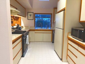 A compact kitchen with a stove, sink, and refrigerator. - Captain's Lookout 3-bedroom house in Dillon Beach perfect for relaxing getaways (Dillon Beach)