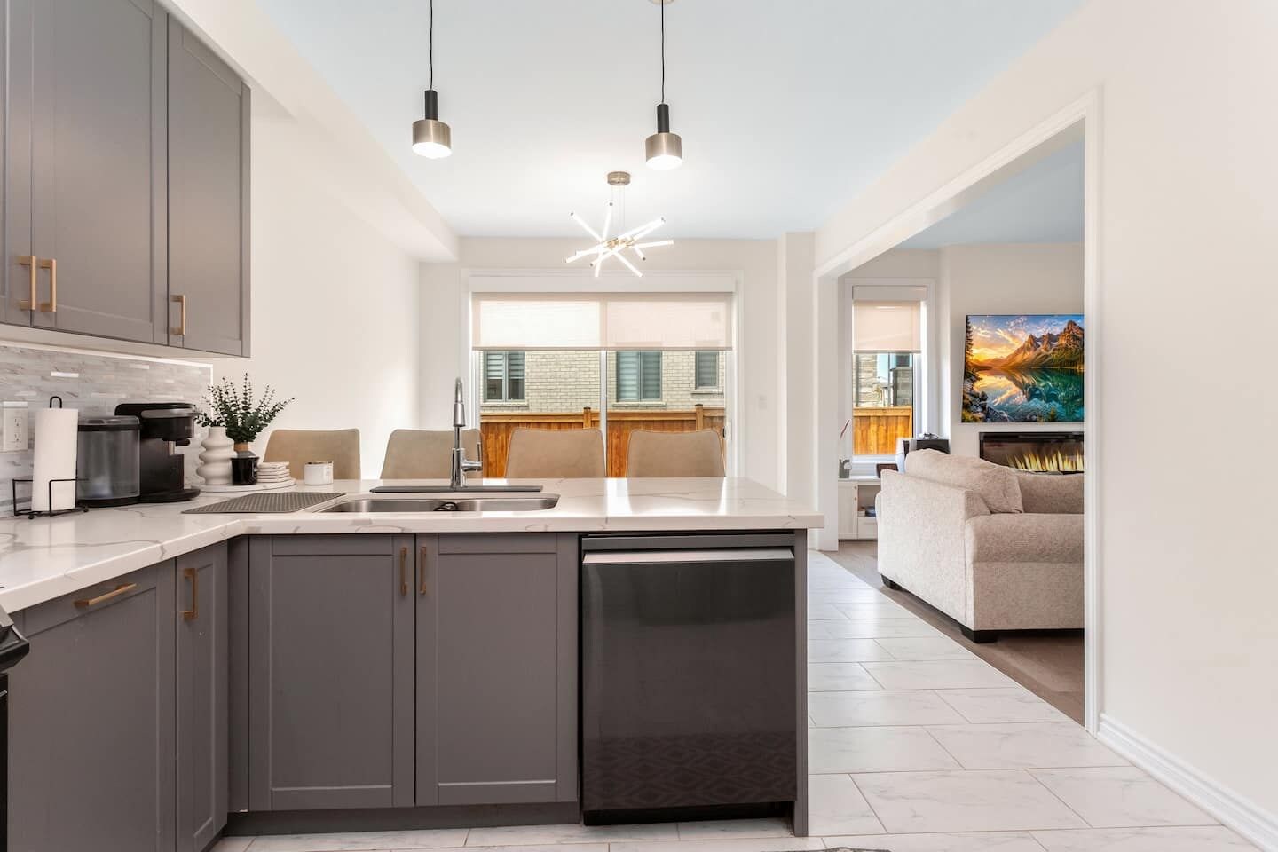 A modern kitchen with a central island, built-in appliances, and pendant lighting.