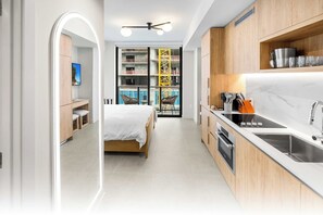 A modern kitchen with a built-in oven, a sink, and a dining area with a table and chairs.