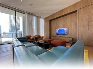 A modern living room with leather sofas, a coffee table, and a television mounted on a wooden wall.