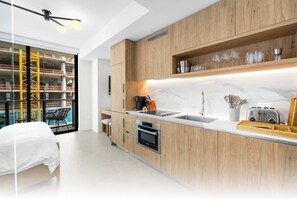 A modern kitchen with wooden cabinets, a built-in oven, and a countertop with a toaster.