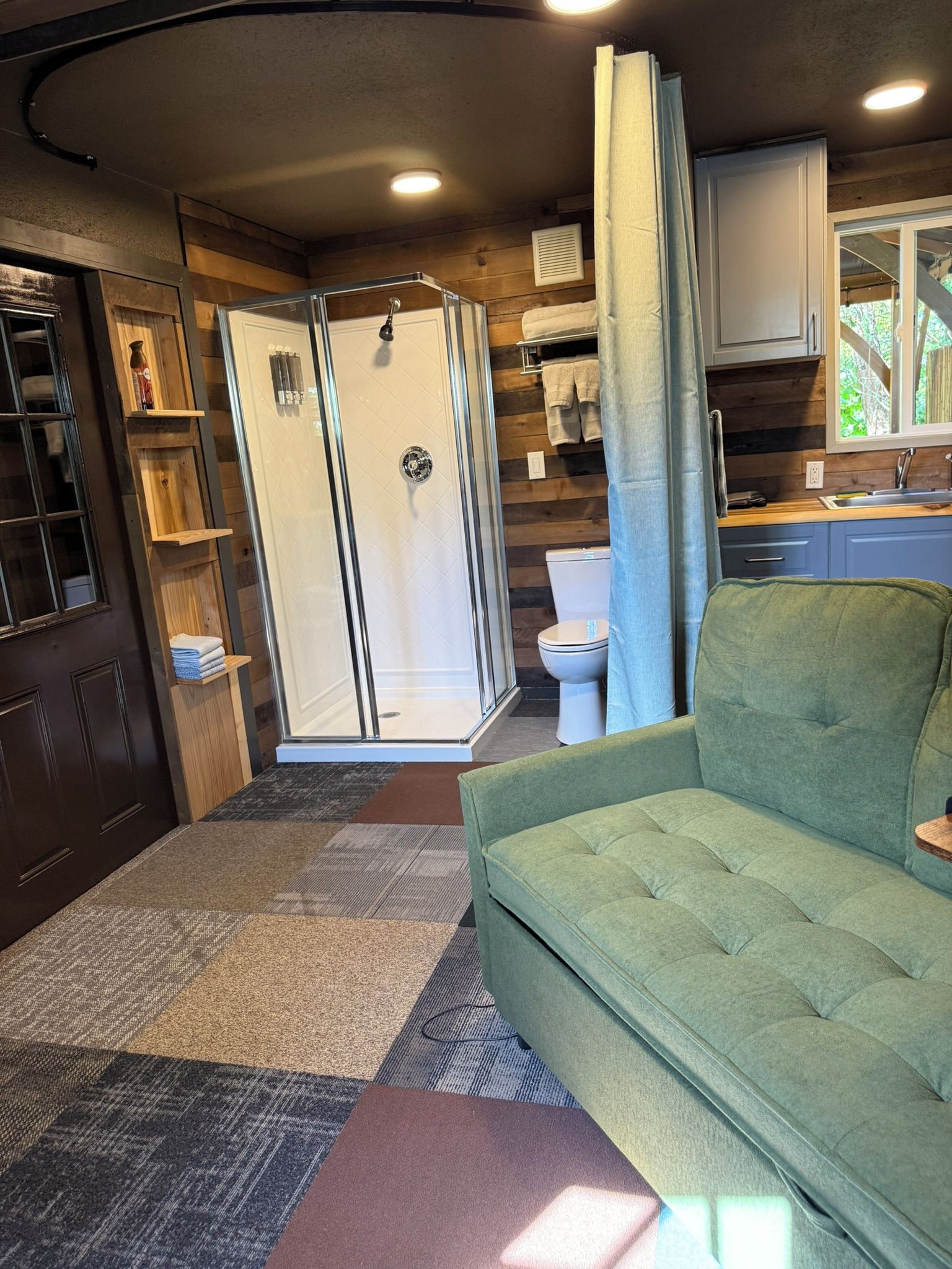 Un espace de vie compact comprenant une douche, des toilettes et une kitchenette.