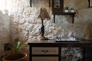 A rustic stone wall, a wooden lamp, a chessboard, and a small potted plant. - VILLA LITHOS, Your Villa (Chania)