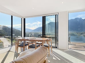 Une pièce moderne avec une grande fenêtre, une table en bois avec des chaises et un canapé.