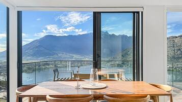 Un comedor con mesa y sillas, ventanas amplias con vista a la montaña.