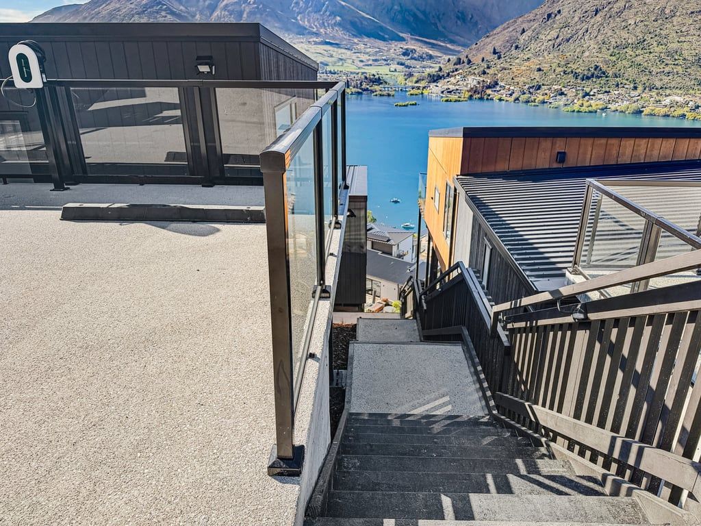 A staircase leading to a building with a view of a lake and mountains.