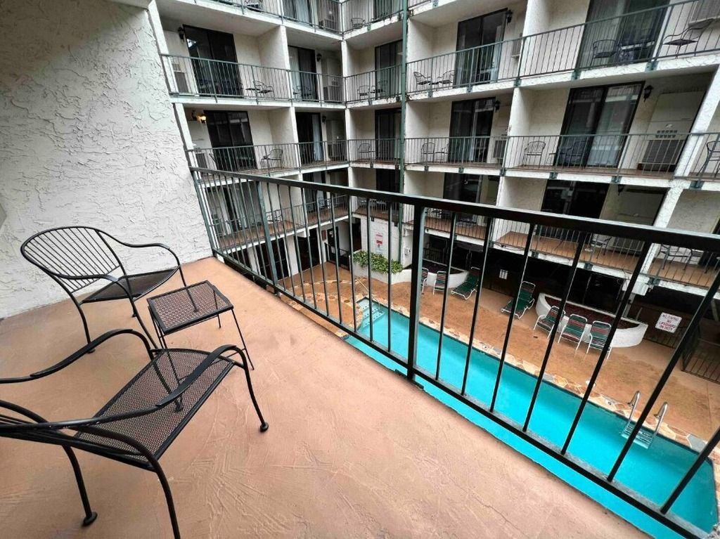 Ein mehrstöckiges Wohngebäude mit Balkonen, einem Schwimmbad und Sitzgelegenheiten im Freien.