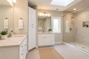 A modern bathroom with a glass shower enclosure, a vanity with a sink, and a large mirror. - Spacious 5BR Arlington Heights Retreat (Arlington Heights)