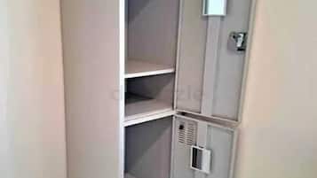 Un placard d’angle avec trois étagères et un petit meuble de rangement.